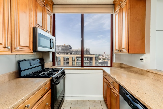 kitchen featuring stainless steel appliances, light stone countertops, and brown cabinetry