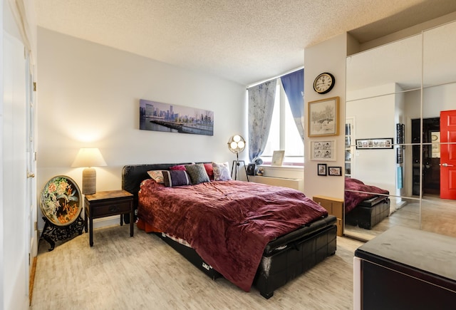 bedroom featuring a textured ceiling and wood finished floors