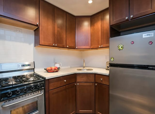 304 W 88th St Unit 1D, New York City, NY 10024 - kitchen with stainless steel appliances, light stone countertops, decorative backsplash, and a sink