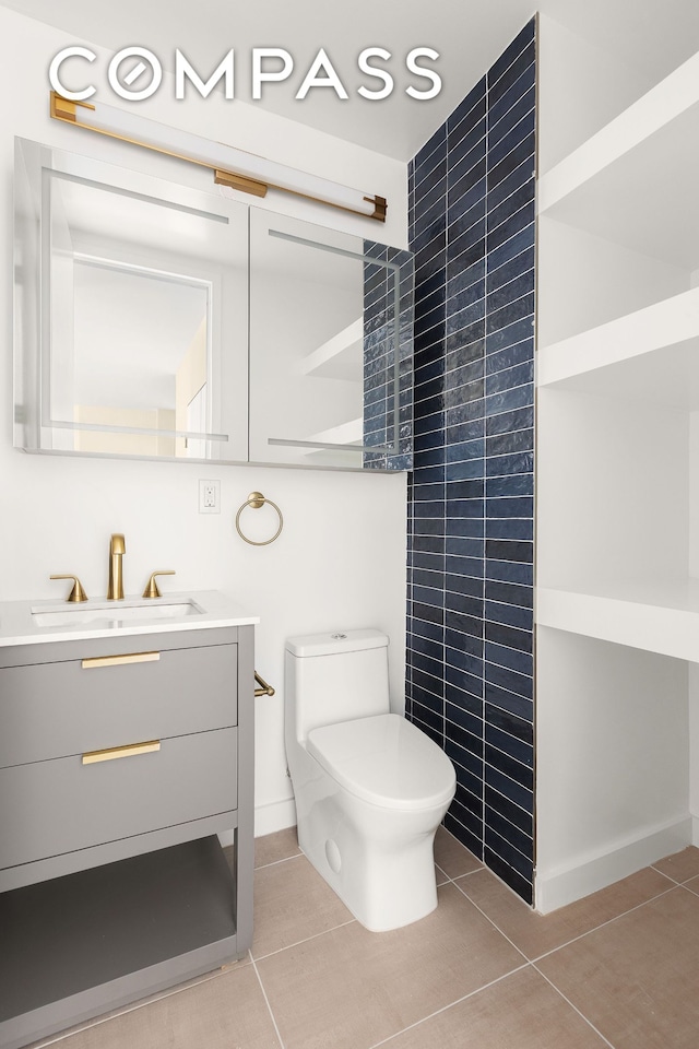 bathroom featuring vanity, tile patterned flooring, and toilet