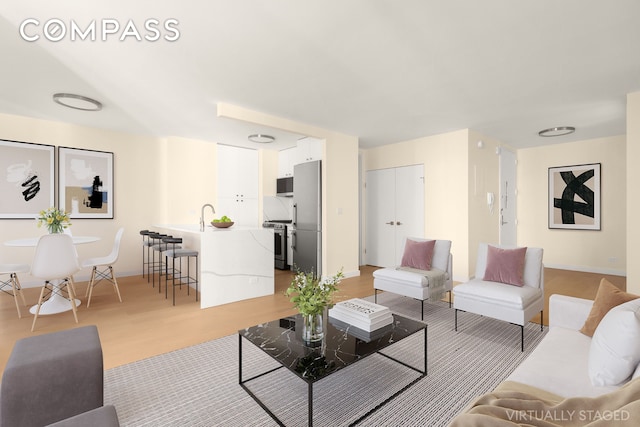 living area featuring baseboards and light wood-style floors