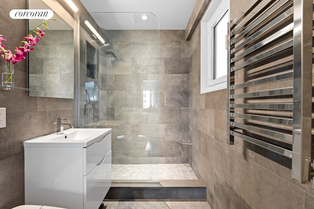full bathroom with vanity, walk in shower, and tile walls