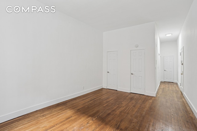 empty room with baseboards and wood finished floors