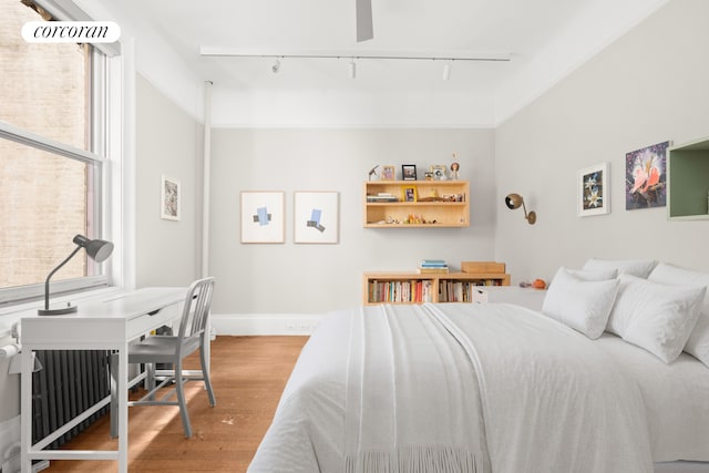 61 Pierrepont St Unit 51/52, New York City, NY 11201 - bedroom featuring rail lighting, wood finished floors, and baseboards