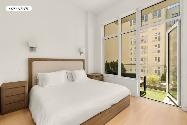 bedroom with access to exterior and wood finished floors
