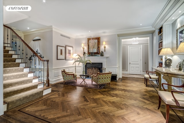 living area featuring wainscoting, stairs, and visible vents
