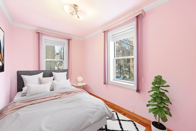 63-61 99th St Unit A-15, New York City, NY 11368 - bedroom with wood finished floors, baseboards, multiple windows, and ornamental molding