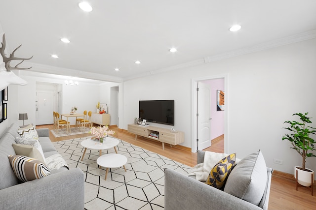 living room featuring recessed lighting, ornamental molding, and light wood-style flooring