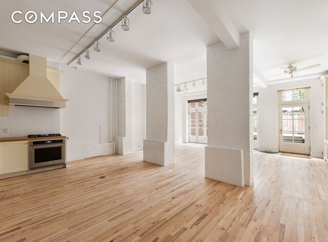 23 W 12th St, New York City, NY 10011 - unfurnished living room with rail lighting, a ceiling fan, and light wood-style floors