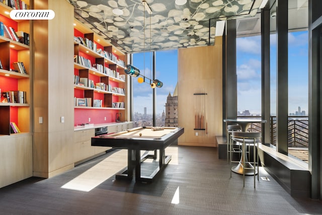 playroom featuring expansive windows, built in features, billiards table, and a city view
