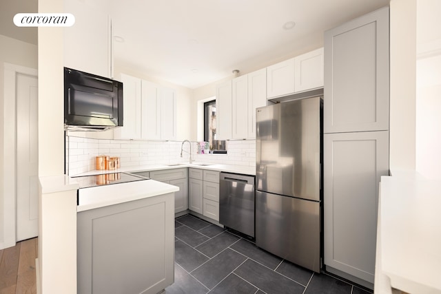 41 Prospect Park SW Unit 2B, New York City, NY 11215 - kitchen featuring black appliances, a sink, decorative backsplash, light countertops, and white cabinetry