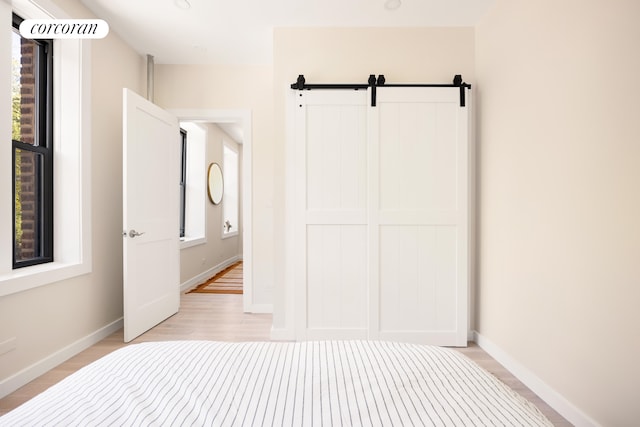 41 Prospect Park SW Unit 2B, New York City, NY 11215 - unfurnished bedroom with light wood-type flooring, baseboards, and a barn door