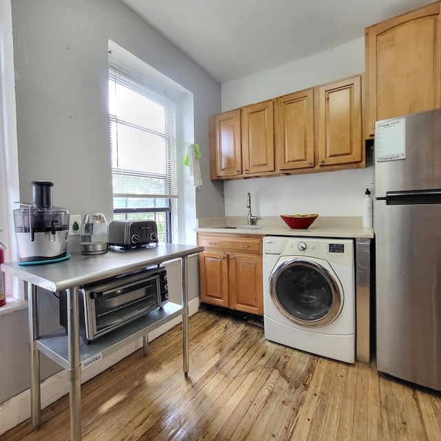 501 W 156th St Unit 34, New York City, NY 10032 - kitchen with washer / dryer, freestanding refrigerator, a sink, light countertops, and light wood-style flooring