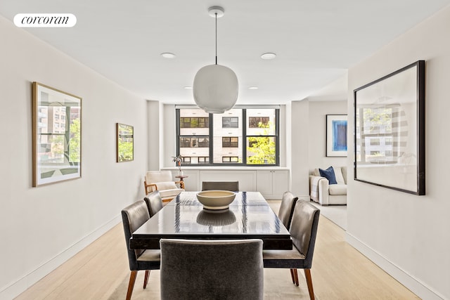 dining space with light wood finished floors, baseboards, healthy amount of natural light, and recessed lighting