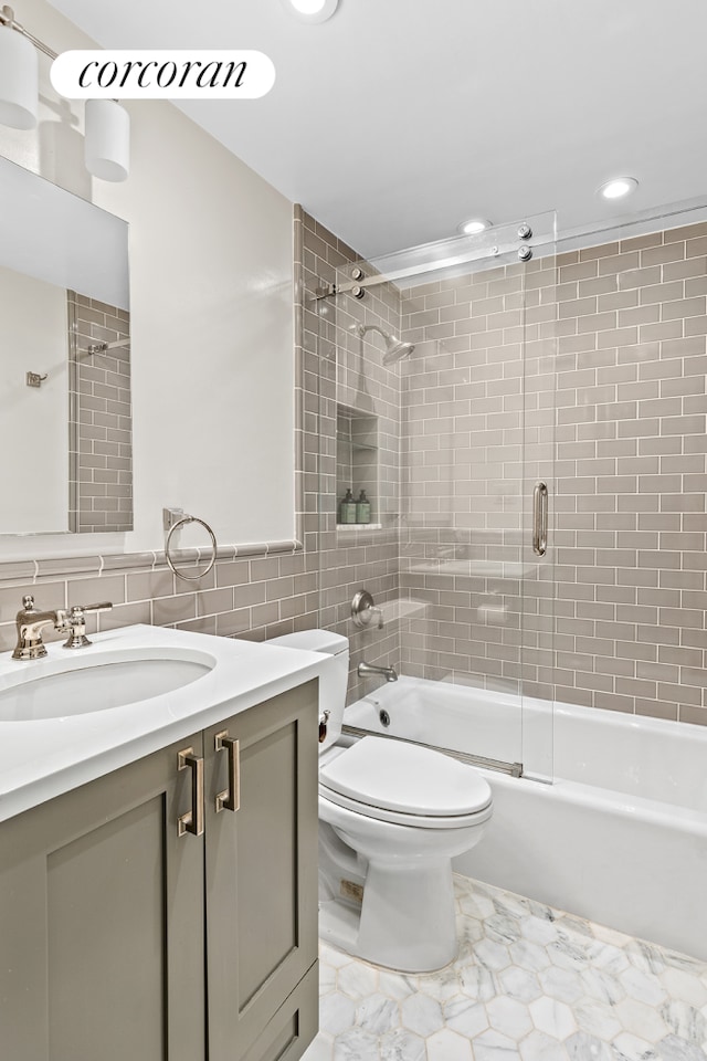 full bath featuring tile walls, vanity, recessed lighting, bath / shower combo with glass door, and toilet
