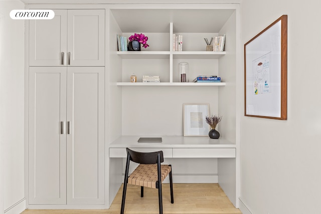 office space with built in study area and light wood finished floors