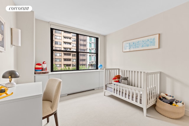 bedroom featuring a crib and carpet flooring