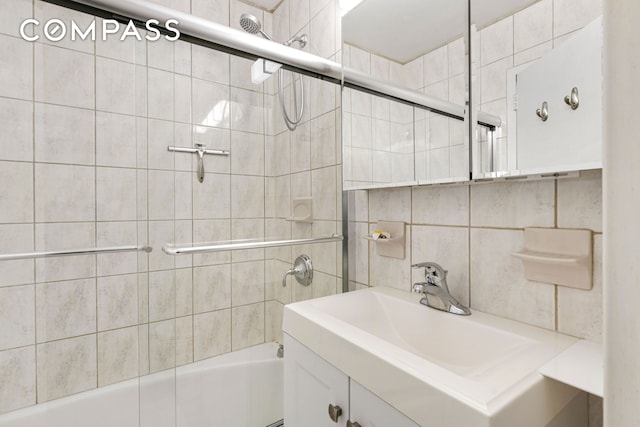 full bath featuring combined bath / shower with glass door, vanity, pet washing area, and tile walls
