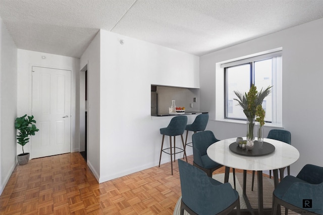 dining space with baseboards and a textured ceiling