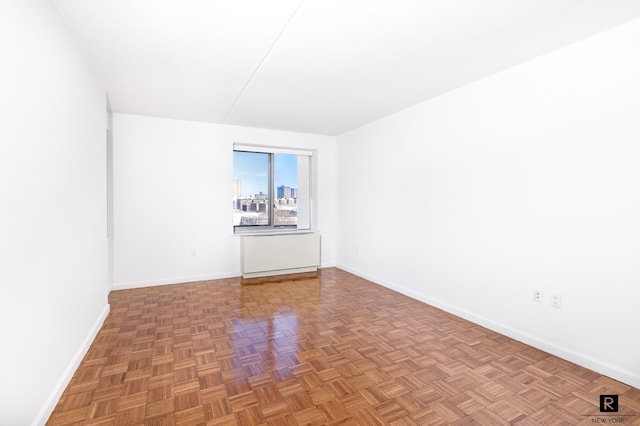 unfurnished room with baseboards
