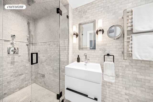 bathroom featuring tile walls, a shower stall, and vanity