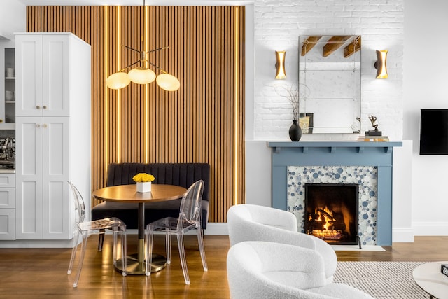 dining room with a tiled fireplace and wood finished floors