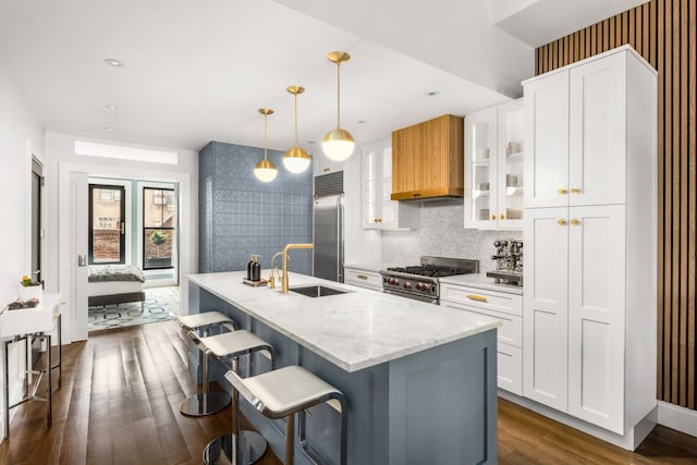 kitchen with high quality appliances, a sink, dark wood-type flooring, plenty of natural light, and wallpapered walls