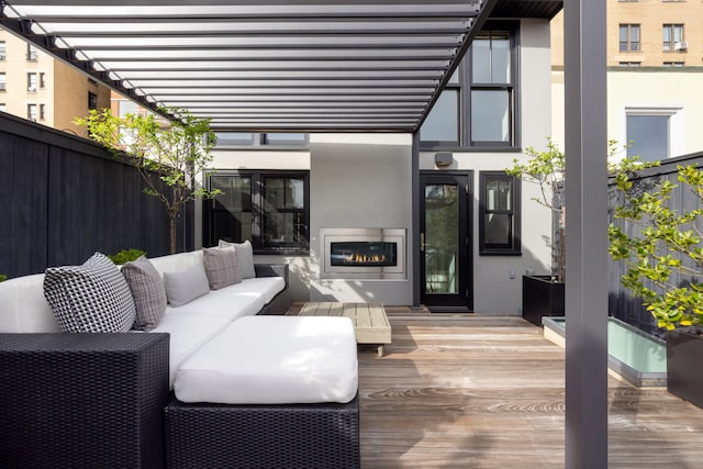 wooden deck with an outdoor hangout area and fence