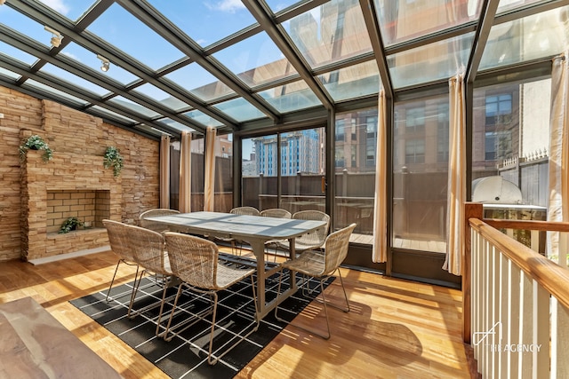 sunroom / solarium featuring vaulted ceiling, outdoor dining area, and a skylight