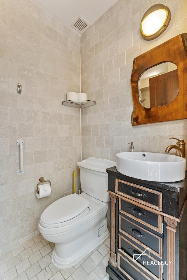 197 E 76th St, New York City, NY 10021 - bathroom featuring tile walls, toilet, and vanity