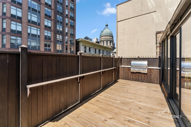 wooden deck with a grill, area for grilling, and fence