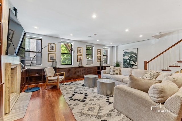 living area featuring recessed lighting, light wood-type flooring, stairs, and cooling unit