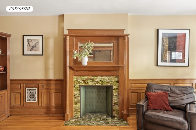 62 Rutland Rd, New York City, NY 11225 - living room featuring a wainscoted wall, wood finished floors, and a tiled fireplace