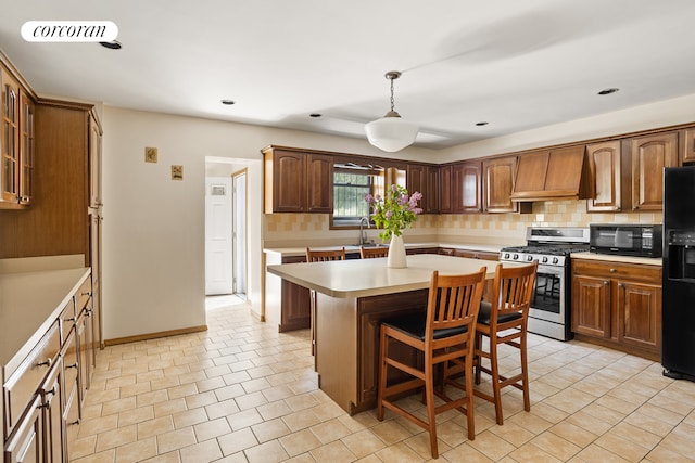62 Rutland Rd, New York City, NY 11225 - kitchen with black appliances, custom exhaust hood, light countertops, a kitchen island, and a breakfast bar