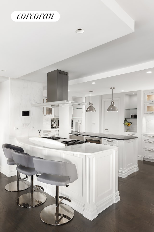 kitchen with a peninsula, white cabinets, stainless steel gas cooktop, and recessed lighting