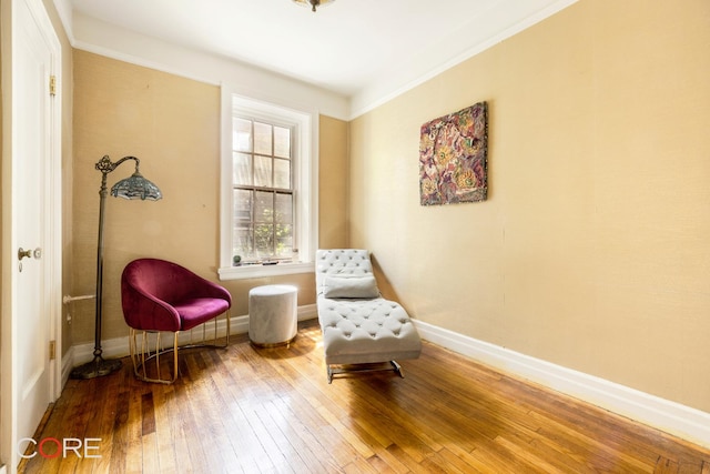 living area featuring baseboards and hardwood / wood-style flooring