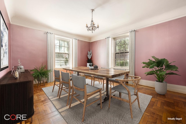 dining room featuring baseboards, a healthy amount of sunlight, and a chandelier