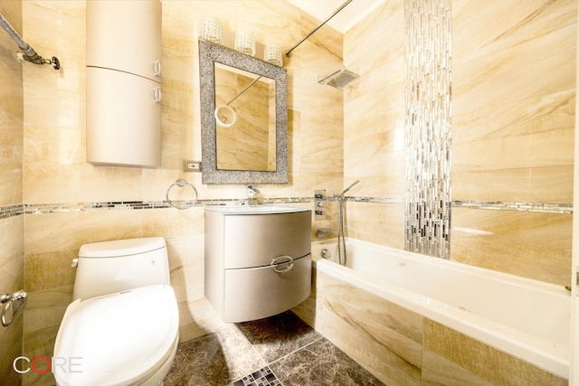 bathroom with tile walls, toilet, tiled shower / bath combo, marble finish floor, and vanity