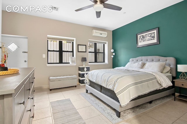 bedroom with an AC wall unit, light tile patterned flooring, baseboards, and a ceiling fan