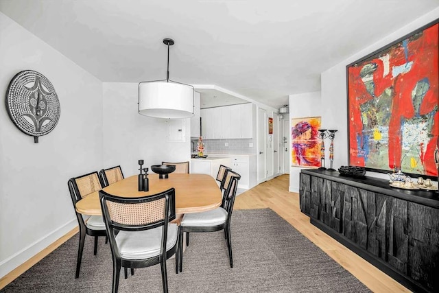 dining area featuring light wood-type flooring and baseboards