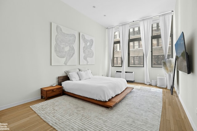 bedroom featuring wood finished floors and baseboards