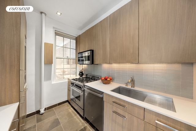 kitchen with appliances with stainless steel finishes, modern cabinets, tasteful backsplash, and light countertops