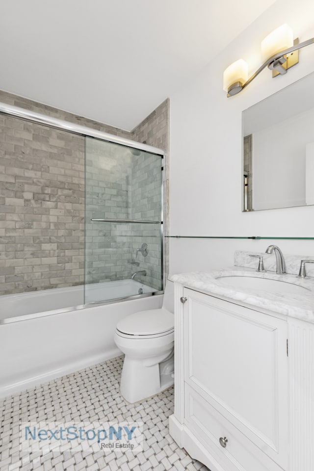 bathroom featuring toilet, enclosed tub / shower combo, and vanity