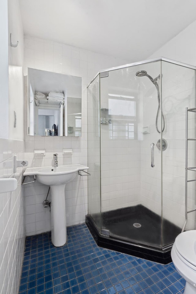 341 W 47th St Unit 4R, New York City, NY 10036 - bathroom featuring tile walls, tile patterned floors, toilet, and a stall shower