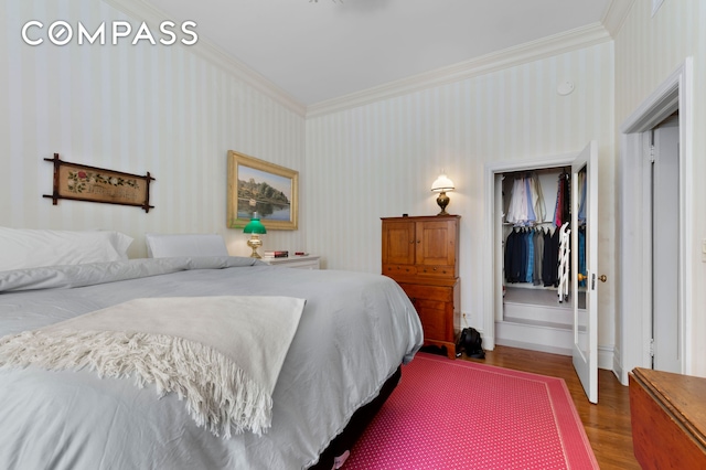 bedroom with ornamental molding, wood finished floors, and baseboards