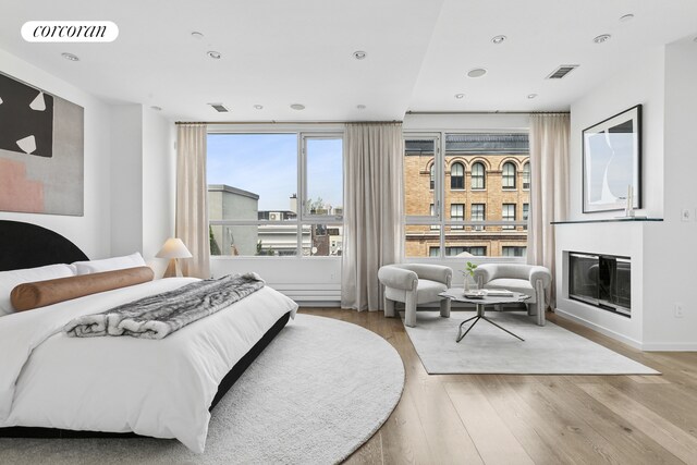 46 Lispenard St Ph, Ph, New York City, NY 10013 - bedroom featuring wood finished floors, a glass covered fireplace, recessed lighting, and baseboards