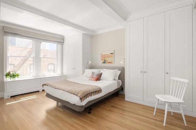 bedroom featuring light wood-type flooring and ornamental molding