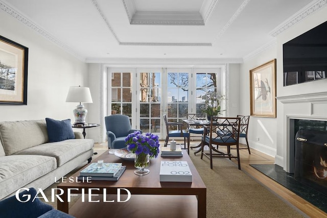 15 Sutton Place, New York City, NY 10022 - living room with a tray ceiling, wood finished floors, a fireplace, ornamental molding, and baseboards