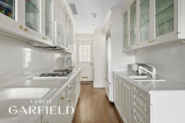 15 Sutton Place, New York City, NY 10022 - kitchen with gas stovetop, white cabinetry, light countertops, and dark wood finished floors