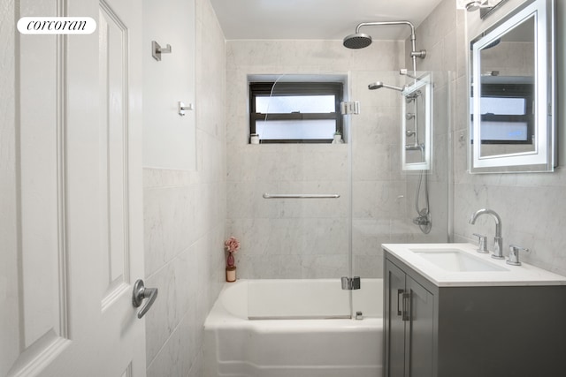 bathroom featuring tile walls, vanity, and bathing tub / shower combination